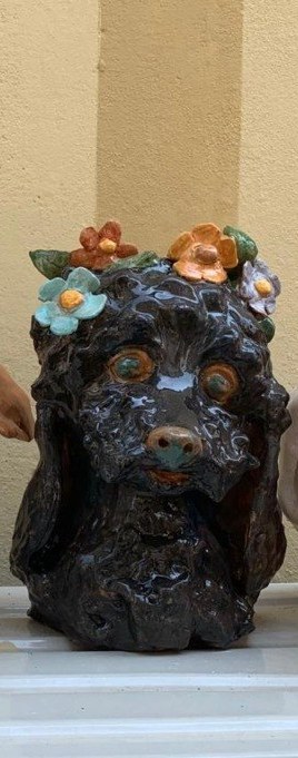 Cane in ceramica smaltata nera, con fiori di ceramica sulla testa