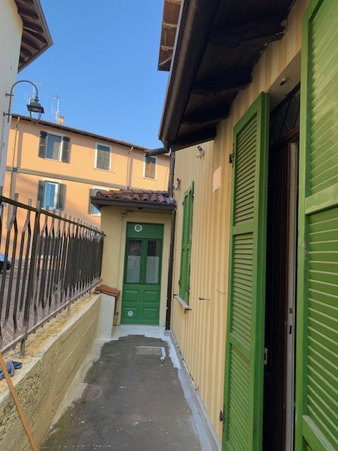 La via stretta di Campoverde con le case gialle e le persiane verdi