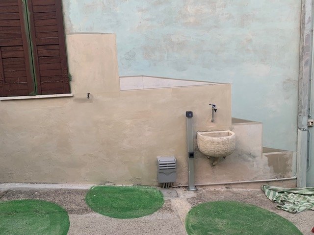 Il cortile con cerchi verdi dipinti sul pavimento e il muro chiaro