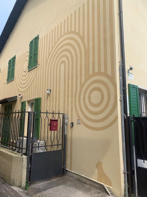 La stessa facciata oggi: giallo tenue con spirali concentriche tono su tono