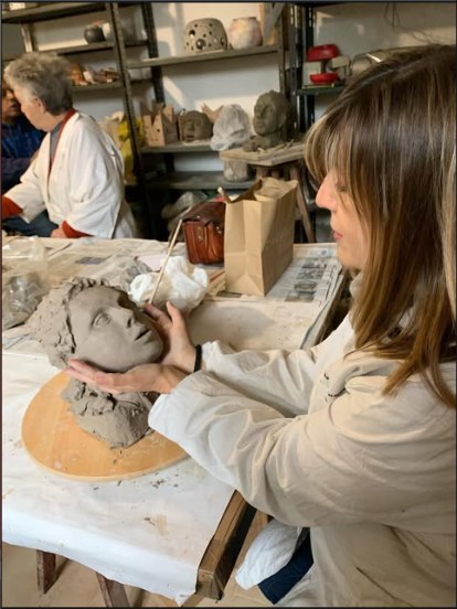 Paola Rovetta in laboratorio mentre modella un volto in creta