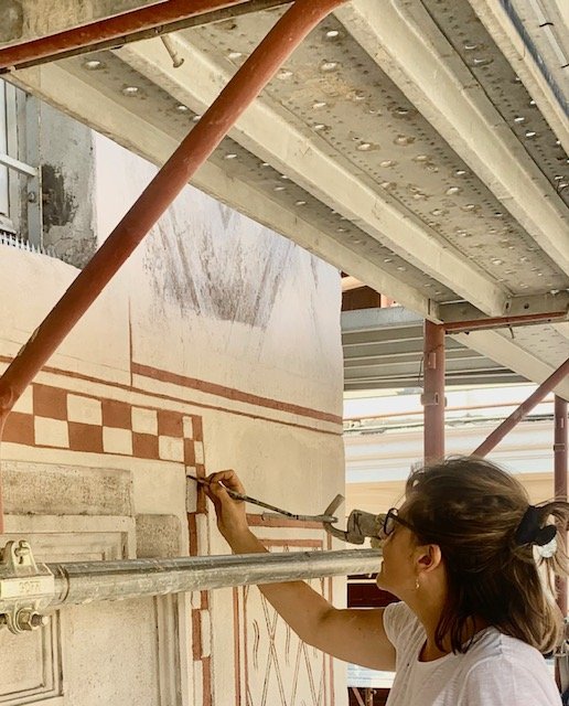 Al lavoro su una parete decorata, dal ponteggio