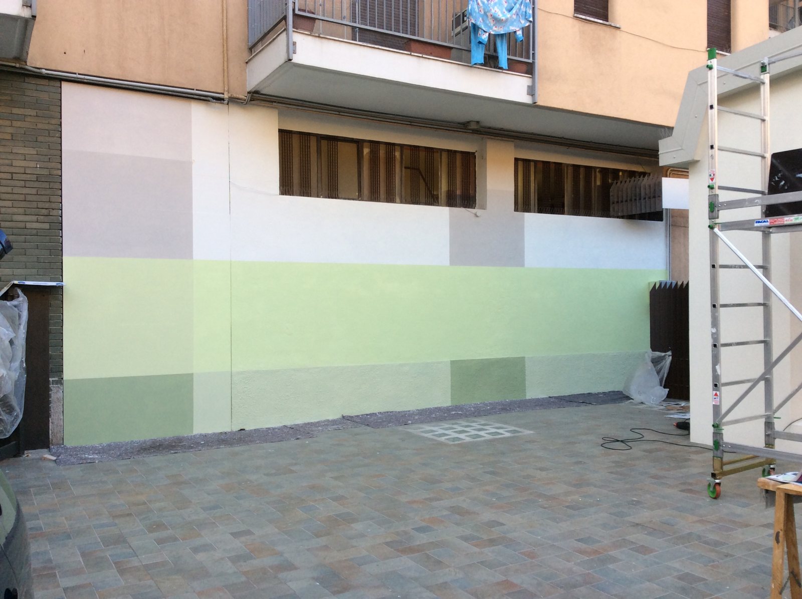 Il muro a metà lavoro, con il trabattello e la prima fascia verde stesa