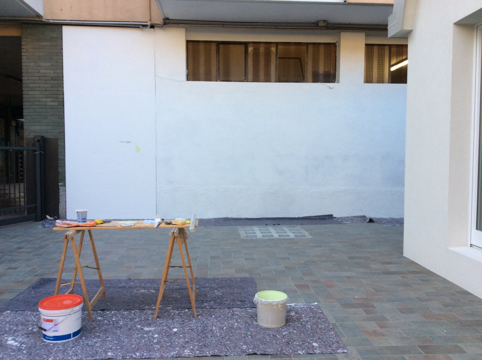 Il muro bianco prima dell'intervento, con il piazzale vuoto